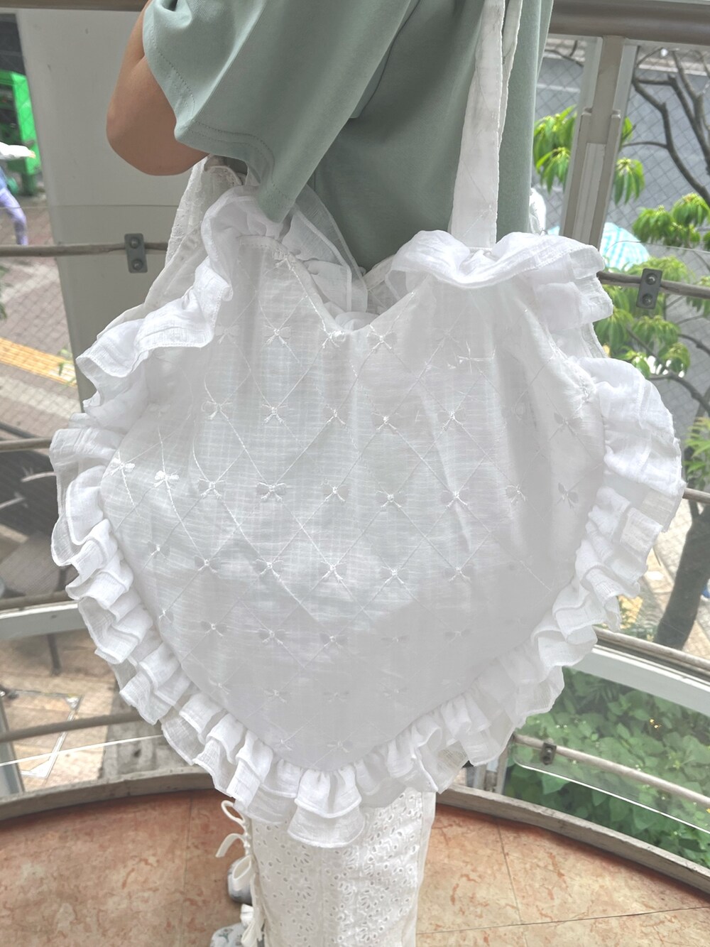 グリーン系のTシャツ/カットソー、ホワイト系のトートバッグ、ホワイト系のデニムパンツを着用したレディースの春コーディネートの9枚目の写真