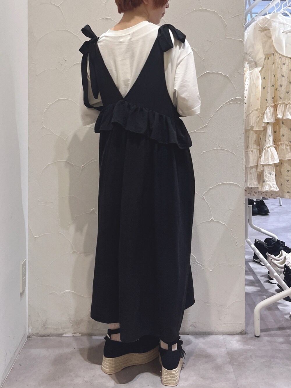 ブラック系のワンピース、ホワイト系のTシャツ/カットソー、ブラック系のサンダルを着用したレディースの春コーディネートの3枚目の写真