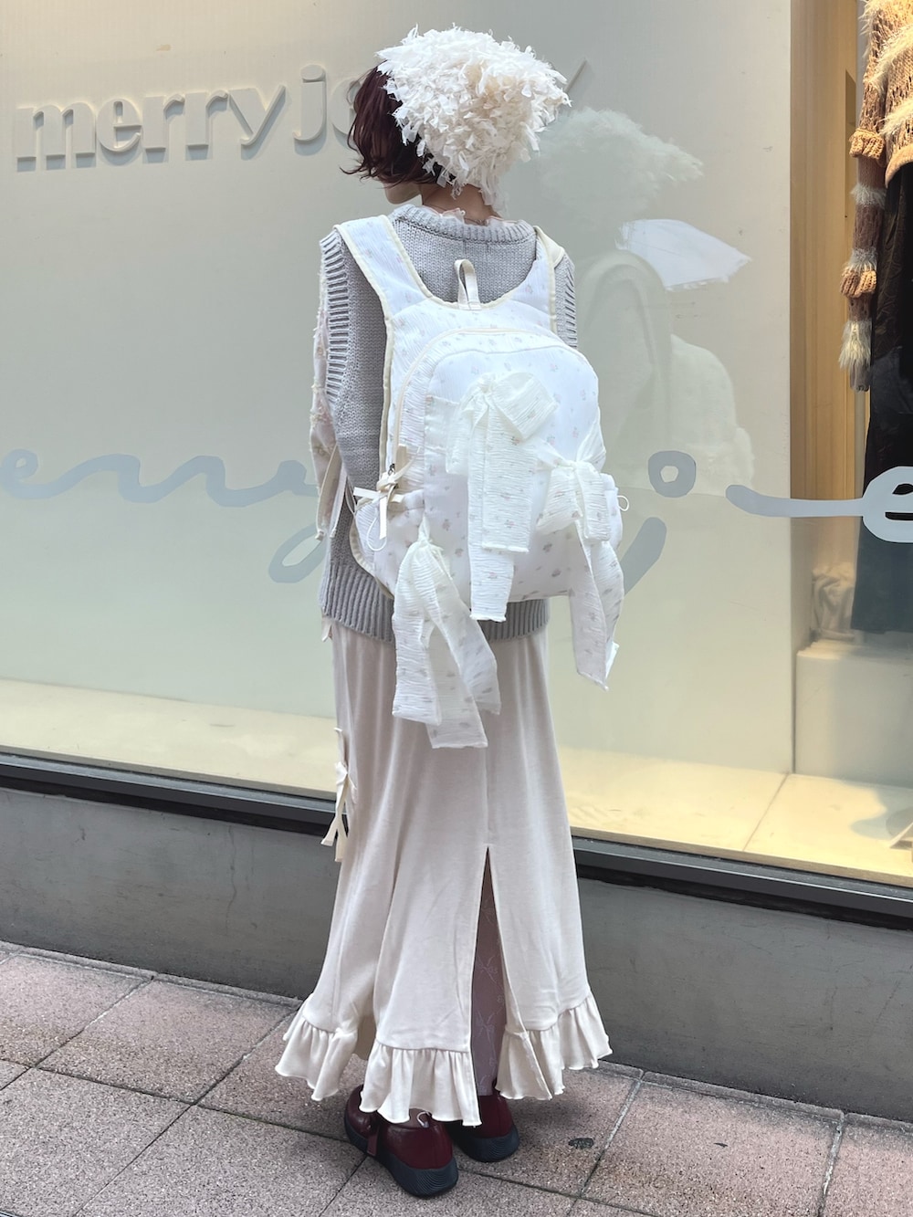 グレー系のベスト、ホワイト系のTシャツ/カットソー、ホワイト系のスカートを着用したレディースの秋コーディネートの4枚目の写真