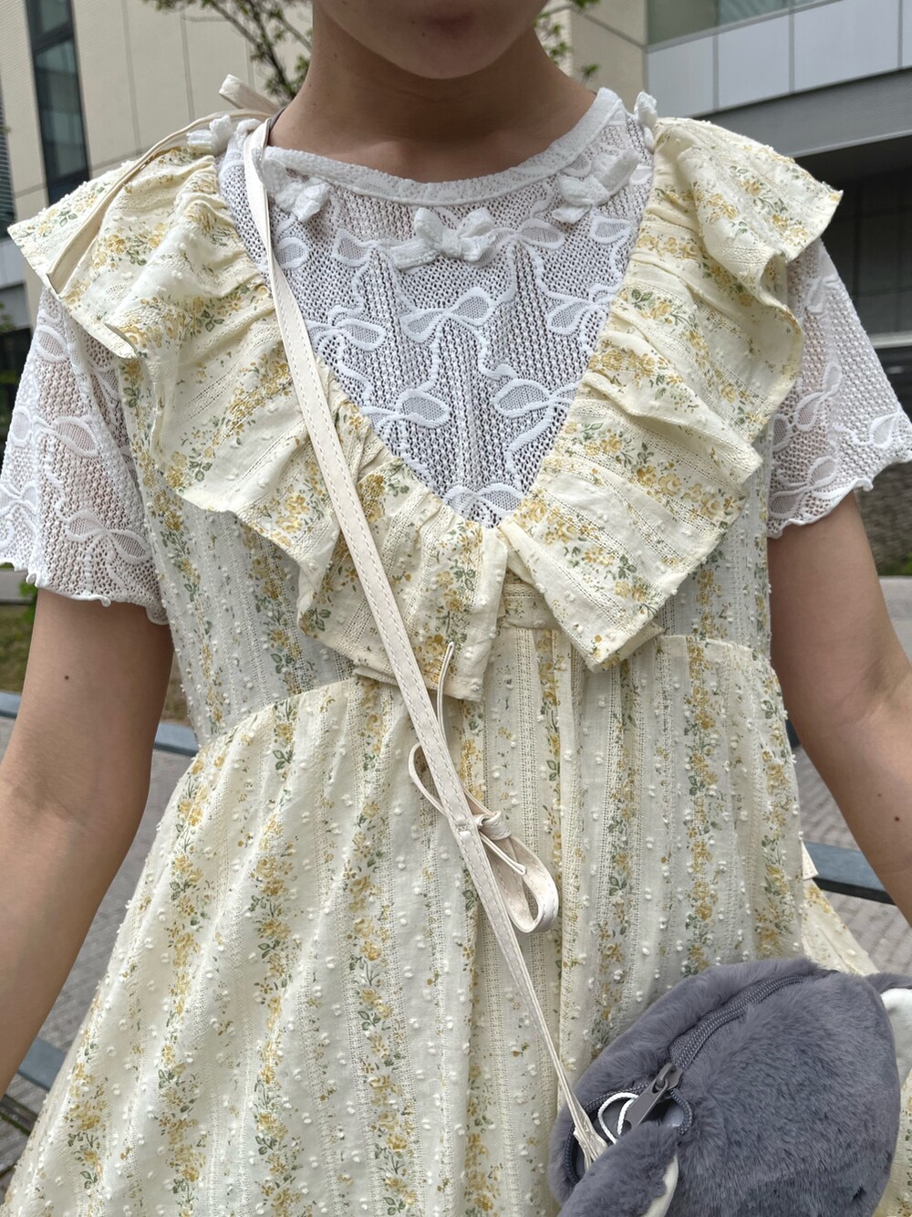 イエロー系のワンピース、ホワイト系のTシャツ/カットソー、グレー系のショルダーバッグを着用したレディースの春コーディネートの7枚目の写真