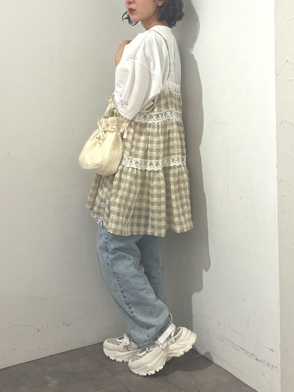 ベージュ系のキャミソール、ホワイト系のTシャツ/カットソー、ホワイト系のショルダーバッグを着用したレディースの春コーディネートの2枚目の写真