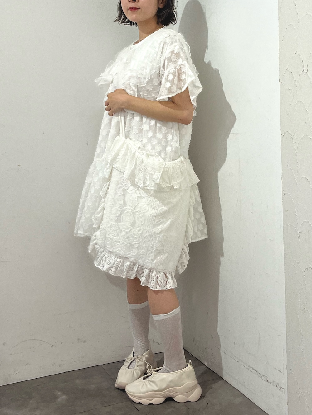 ホワイト系のワンピース、ホワイト系のトートバッグ、ホワイト系のスニーカーを着用したレディースの夏コーディネートの3枚目の写真