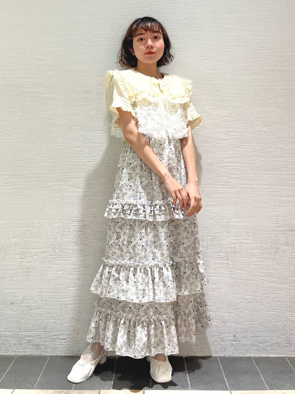 イエロー系のシャツ/ブラウス、ホワイト系のキャミソール、イエロー系のスカートを着用したレディースの夏コーディネートの2枚目の写真