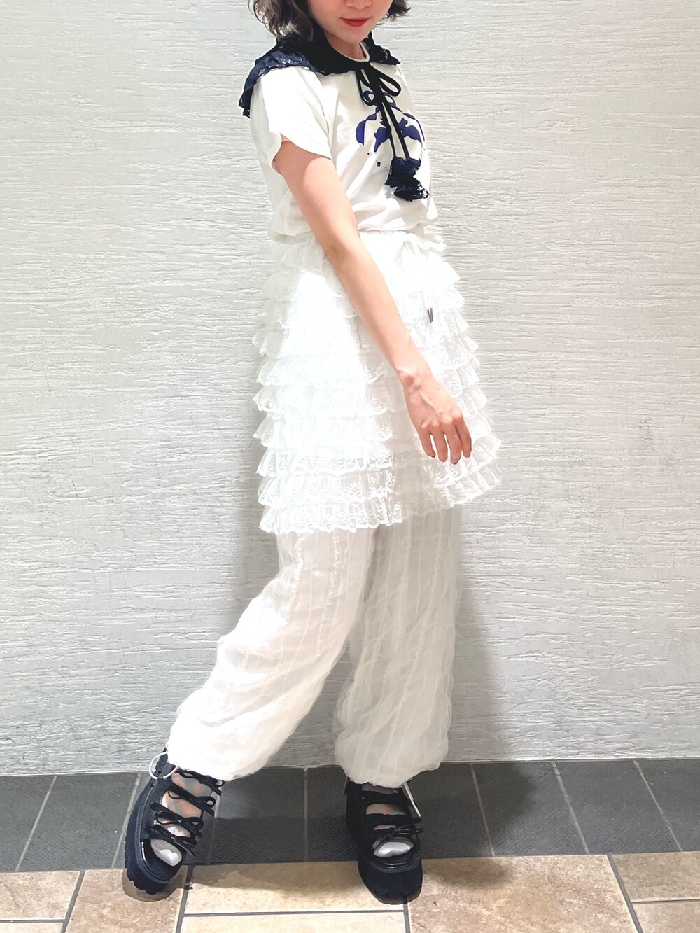 ホワイト系のスカート、ホワイト系のカーゴパンツ、ブラック系のサンダルを着用したレディースの春コーディネートの3枚目の写真