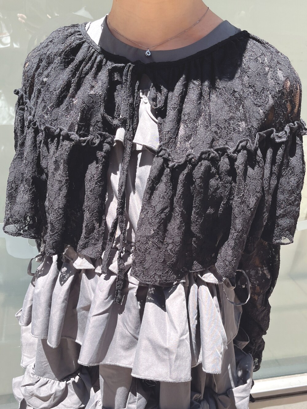 グレー系のワンピース、ブラック系のカーディガン/ボレロ、ブラック系のサンダルを着用したレディースの夏コーディネートの8枚目の写真