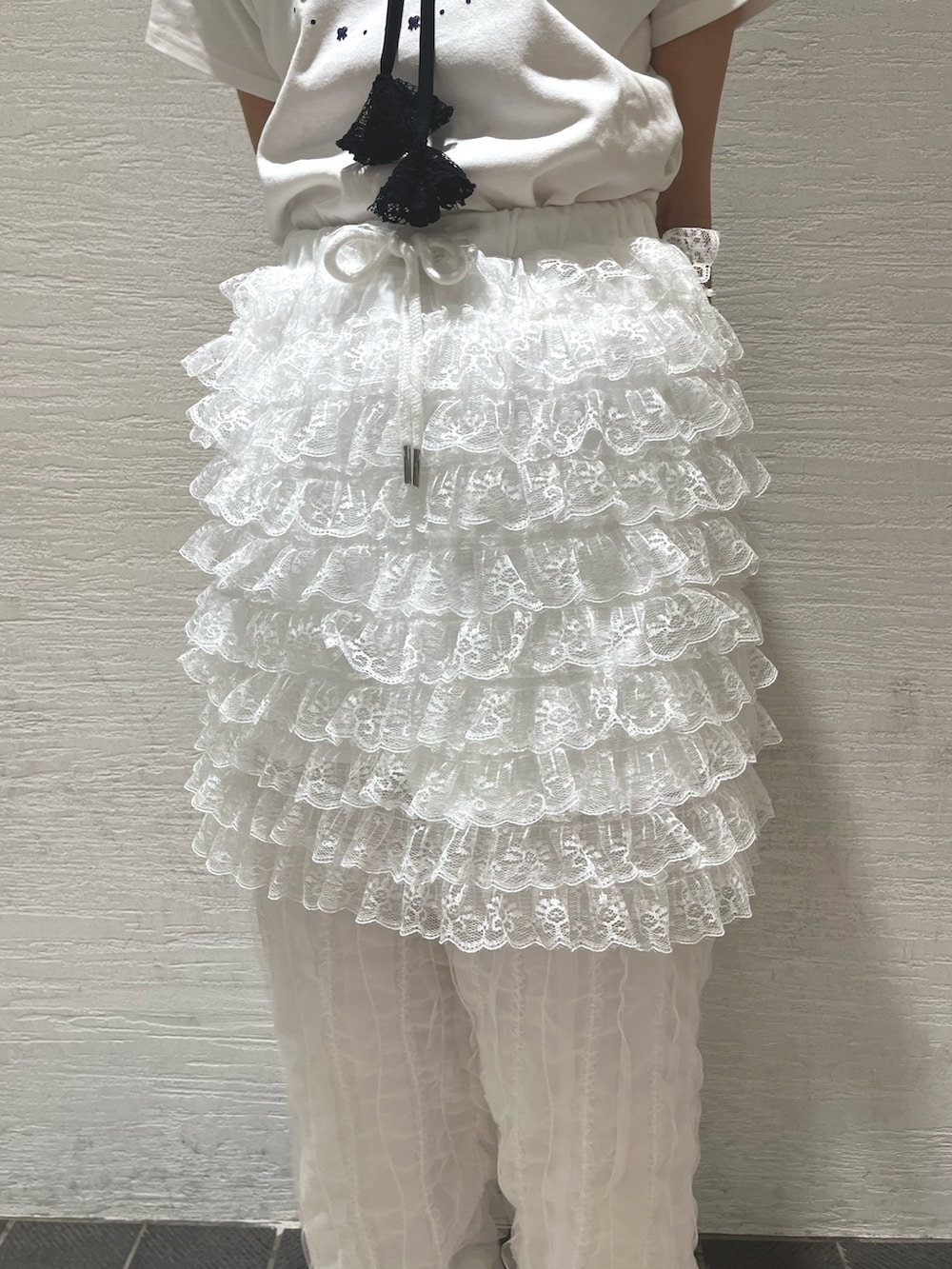 ホワイト系のスカート、ホワイト系のカーゴパンツ、ブラック系のサンダルを着用したレディースの春コーディネートの8枚目の写真