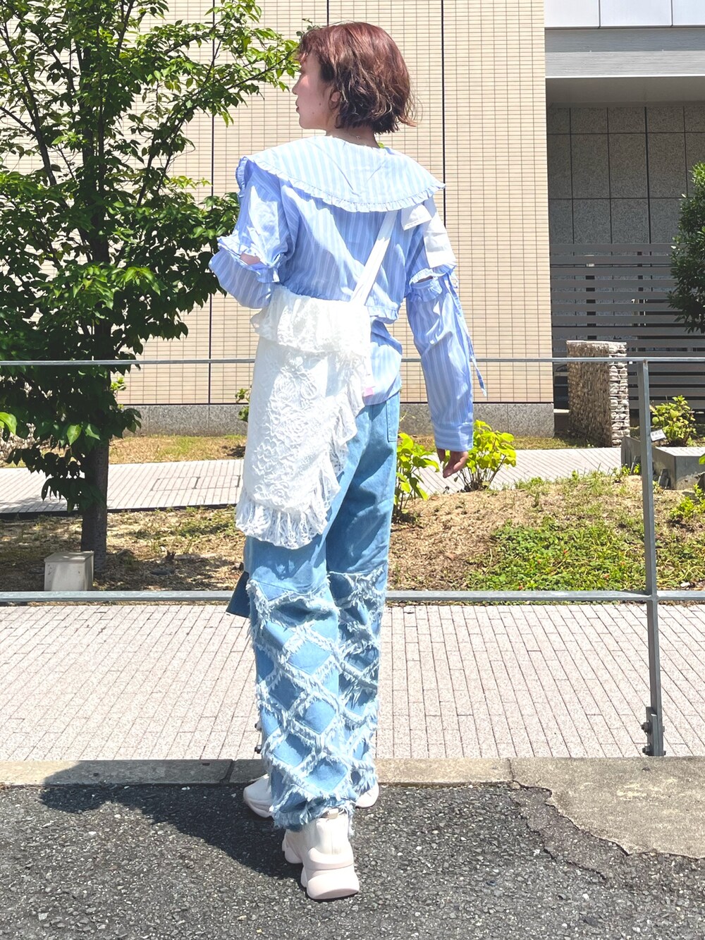 ブルー系のシャツ/ブラウス、ホワイト系のトートバッグ、ブルー系のデニムパンツを着用したレディースの夏コーディネートの3枚目の写真