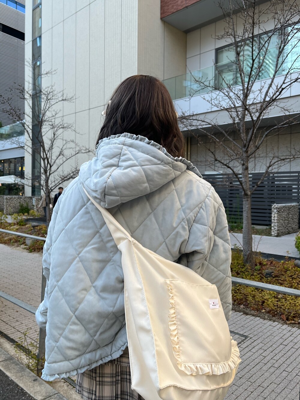 ブルー系のダウンジャケット/コート、ベージュ系のスカート、ホワイト系のトートバッグを着用したレディースの冬コーディネートの4枚目の写真
