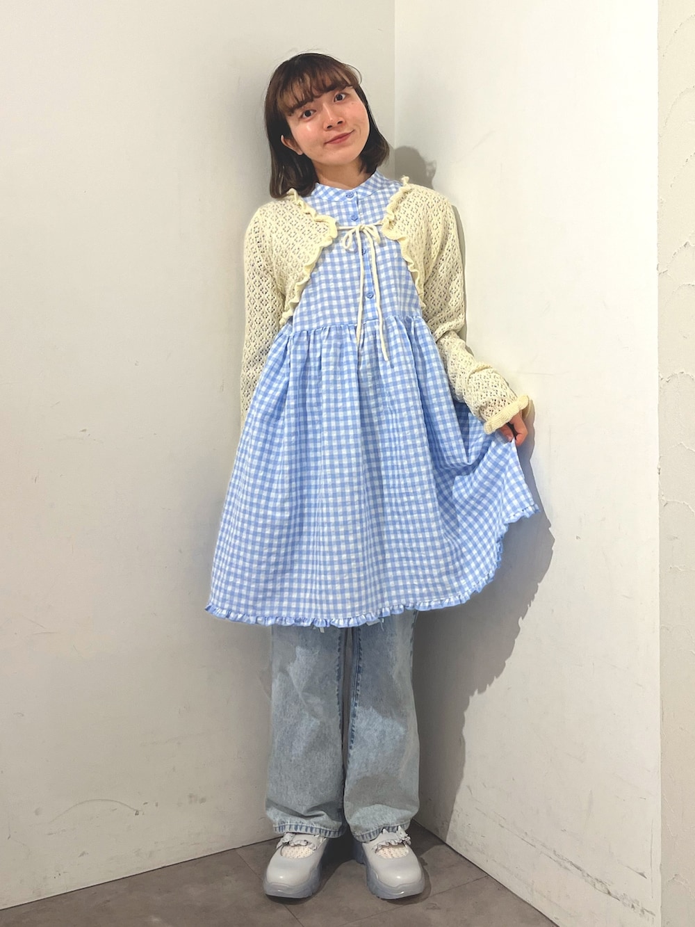 ブルー系のワンピース、ホワイト系のカーディガン/ボレロ、ブルー系のデニムパンツを着用したレディースの春コーディネートの2枚目の写真