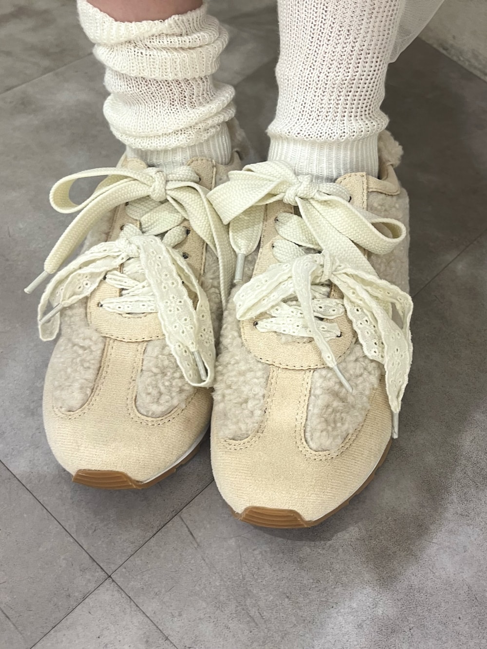 ピンク系のボストンバッグ、ホワイト系のニット/セーター、ホワイト系のワンピースを着用したレディースの秋コーディネートの9枚目の写真