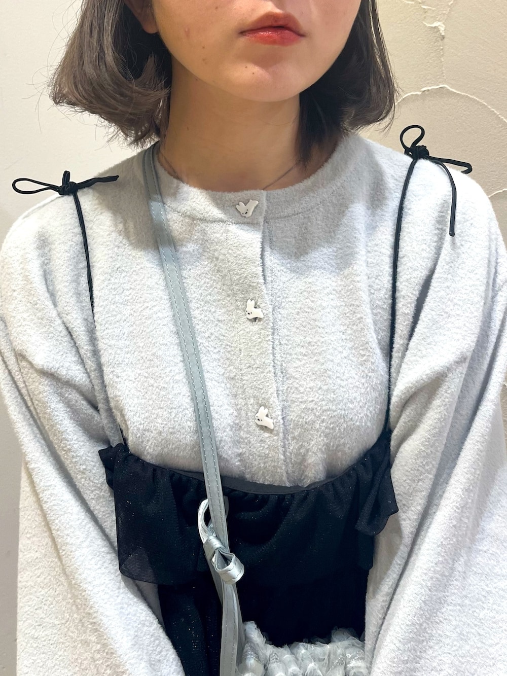 ブラック系のワンピース、ブルー系のショルダーバッグ、ホワイト系のパンプスを着用したレディースの春コーディネートの9枚目の写真