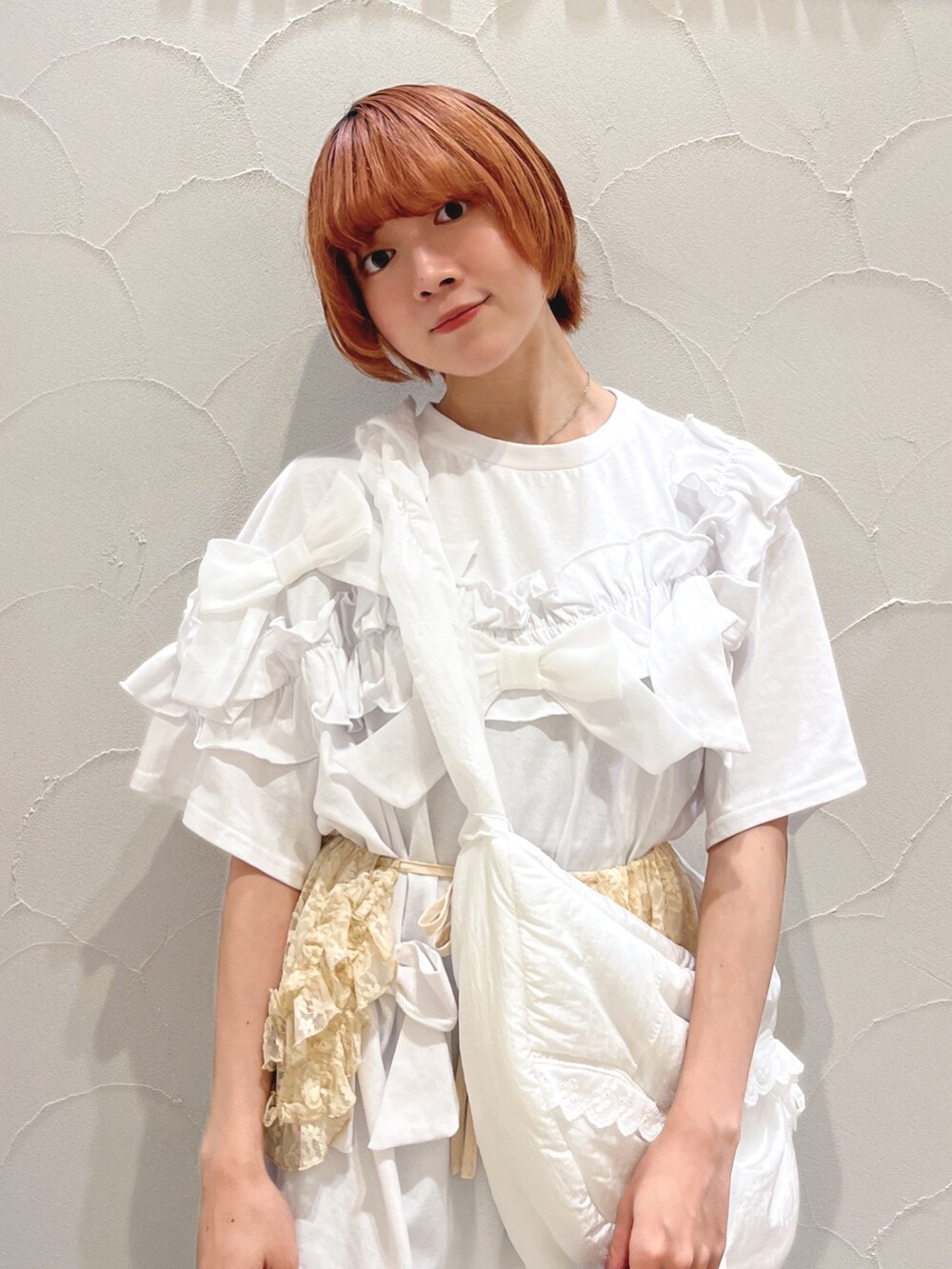 ホワイト系のショルダーバッグ、ホワイト系のTシャツ/カットソー、ブルー系のスラックスを着用したレディースの夏コーディネートの5枚目の写真