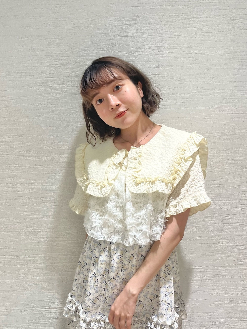 イエロー系のシャツ/ブラウス、ホワイト系のキャミソール、イエロー系のスカートを着用したレディースの夏コーディネートの6枚目の写真