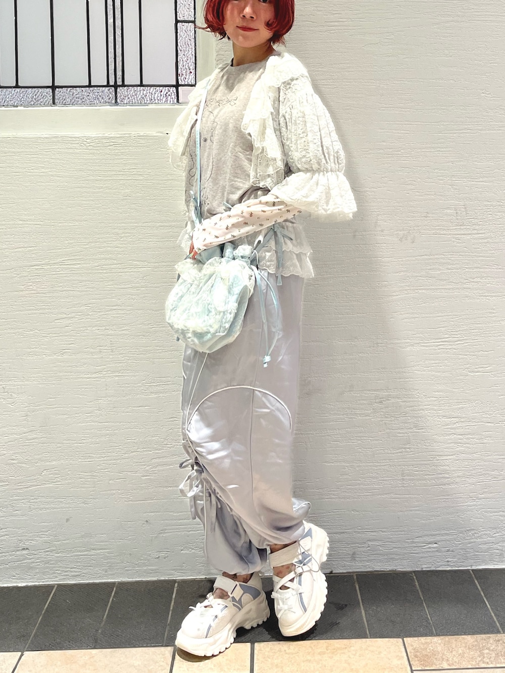 ブルー系のショルダーバッグ、グレー系のTシャツ/カットソー、ホワイト系のカーディガン/ボレロを着用したレディースの秋コーディネートの3枚目の写真