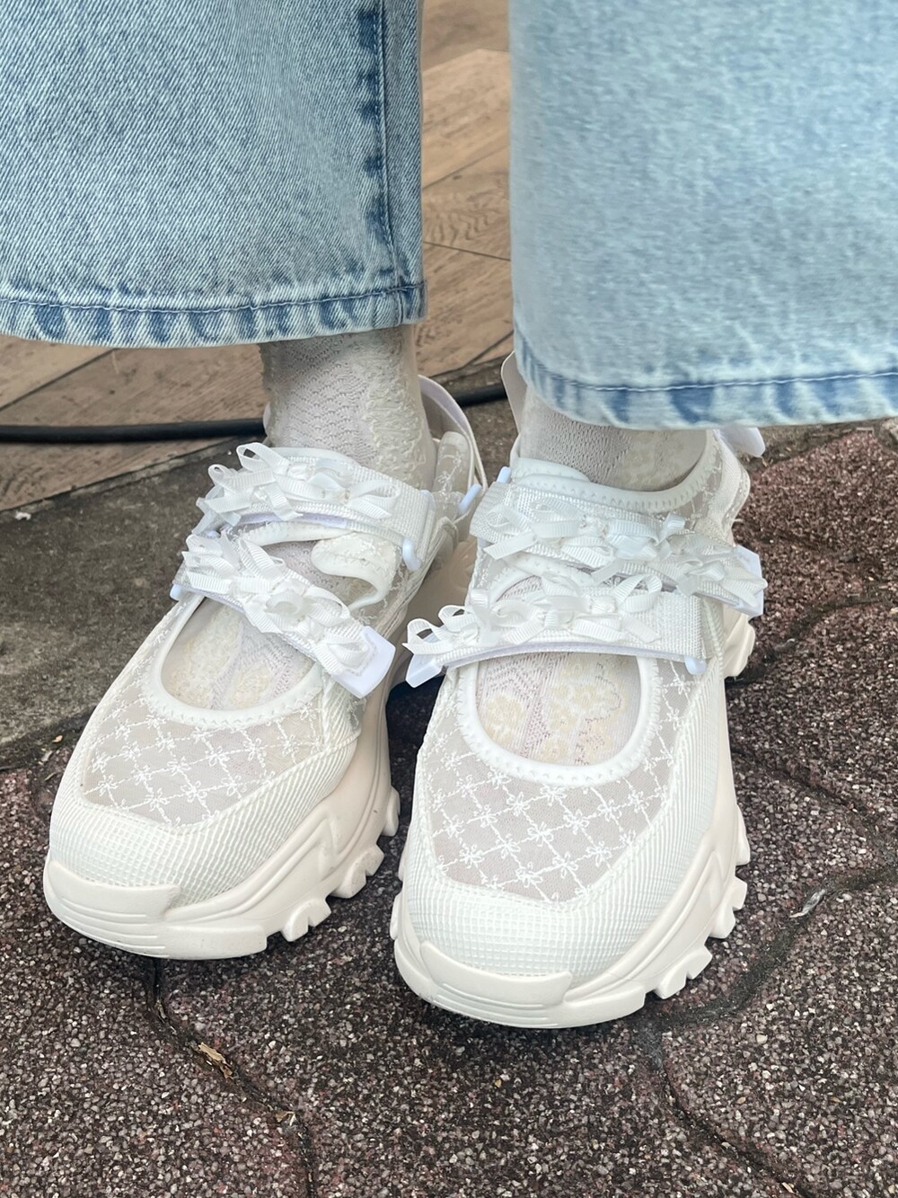 ホワイト系のショルダーバッグ、ホワイト系のニット/セーター、ブルー系のシャツ/ブラウスを着用したレディースの冬コーディネートの8枚目の写真