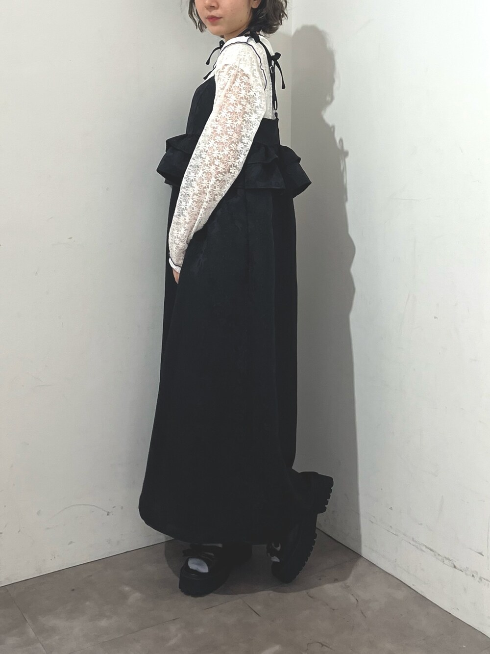 ブラック系のワンピース、ホワイト系のTシャツ/カットソー、ブラック系のサンダルを着用したレディースの春コーディネートの4枚目の写真