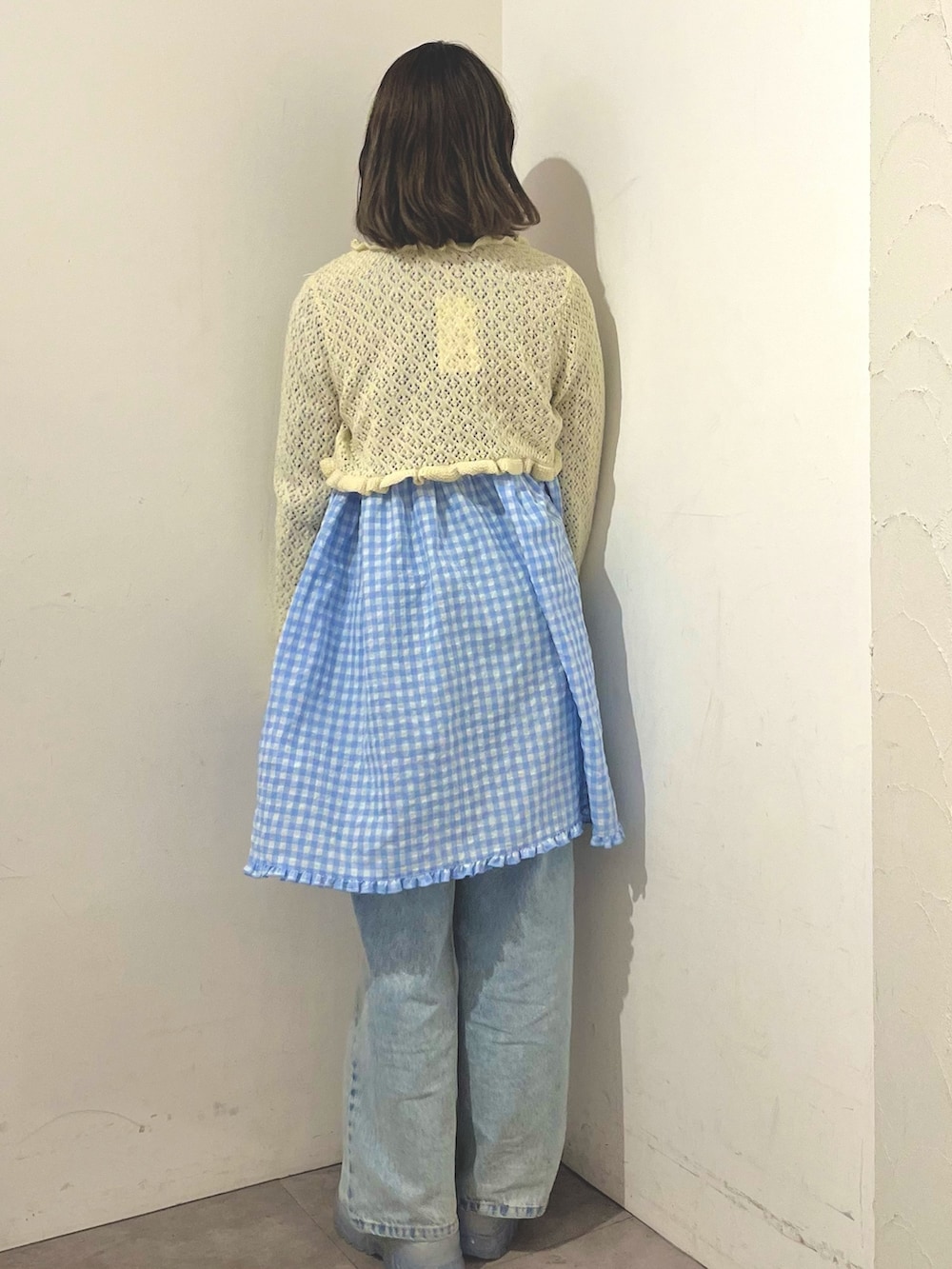 ブルー系のワンピース、ホワイト系のカーディガン/ボレロ、ブルー系のデニムパンツを着用したレディースの春コーディネートの4枚目の写真