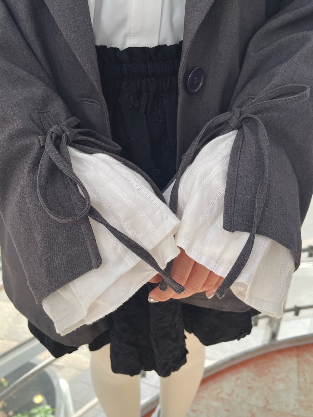 グレー系のテーラードジャケット、ホワイト系のシャツ/ブラウス、ブラック系のスカートを着用したレディースの冬コーディネートの8枚目の写真