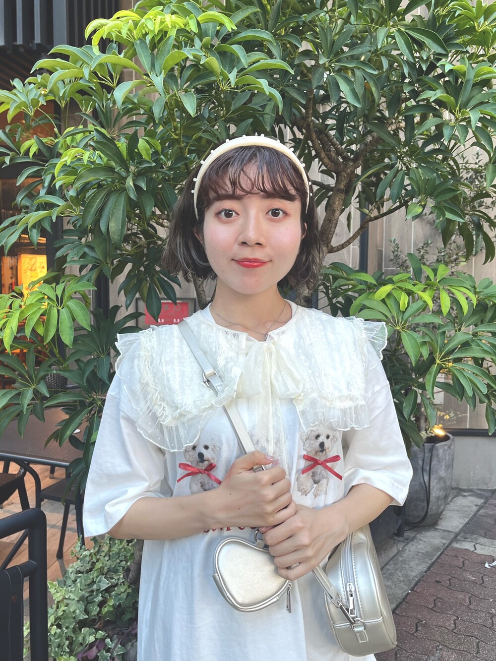 ホワイト系のTシャツ/カットソー、ゴールド系のショルダーバッグ、ブラウン系のスラックスを着用したレディースの夏コーディネートの4枚目の写真