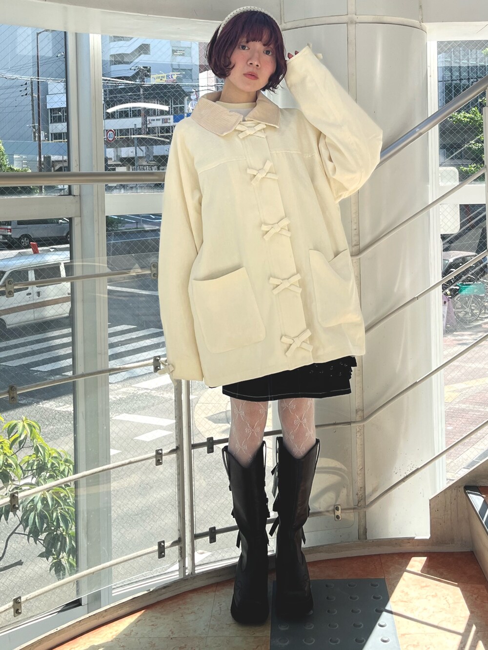 ブラック系のチュニック、イエロー系のTシャツ/カットソー、ホワイト系のブルゾンを着用したレディースの秋コーディネートの5枚目の写真