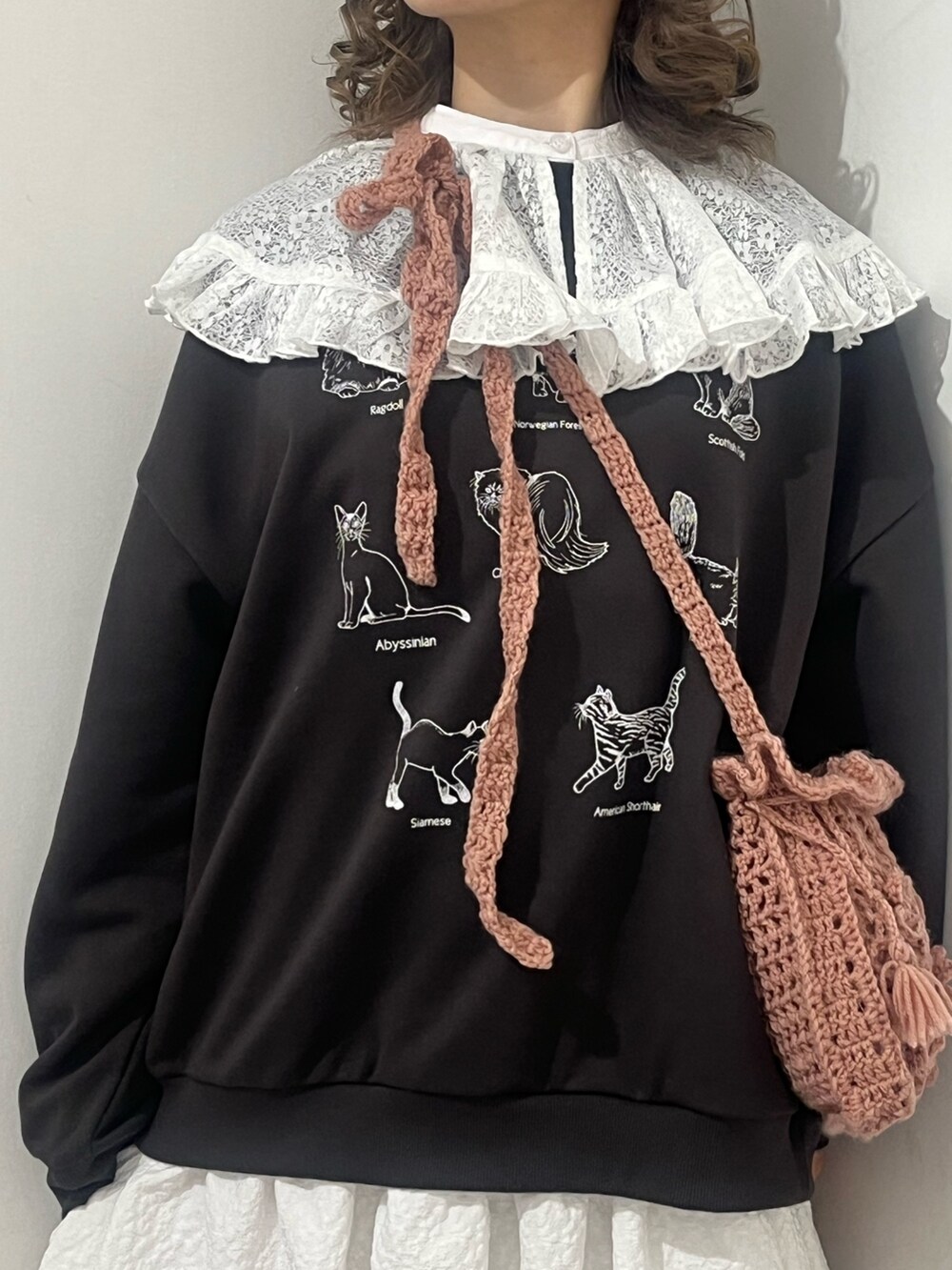 ホワイト系のシャツ/ブラウス、グレー系のスウェット、ピンク系のハンドバッグを着用したレディースの冬コーディネートの5枚目の写真