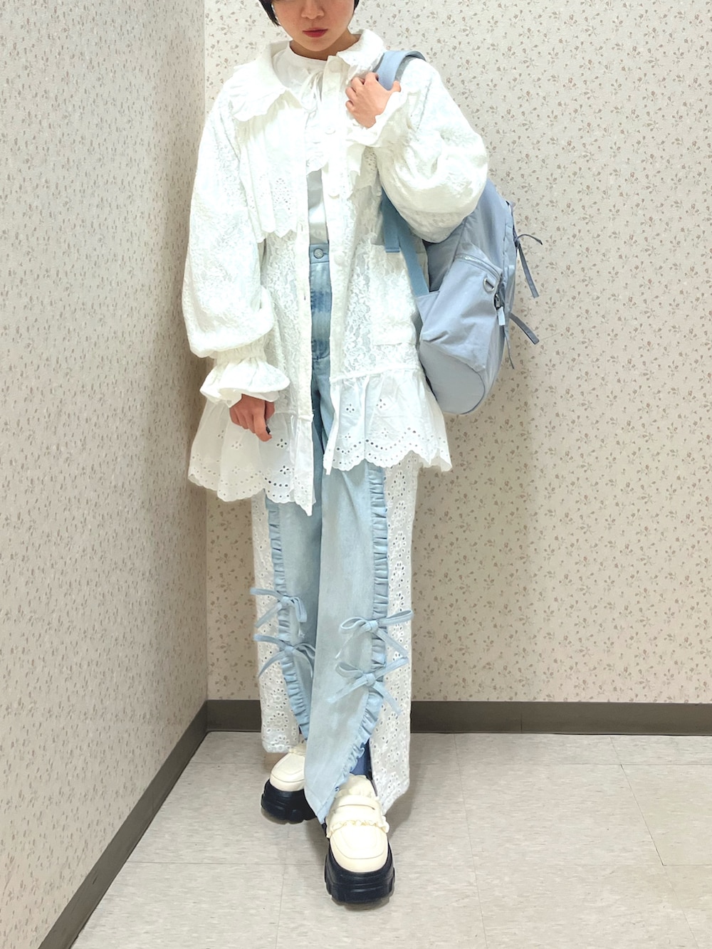 ブルー系のデニムパンツ、ホワイト系のシャツ/ブラウス、ホワイト系のテーラードジャケットを着用したレディースの冬コーディネートの2枚目の写真