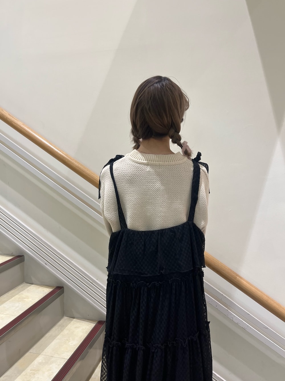 ブラック系のワンピース、ホワイト系のニット/セーター、ブラック系のパンプスを着用したレディースの冬コーディネートの5枚目の写真