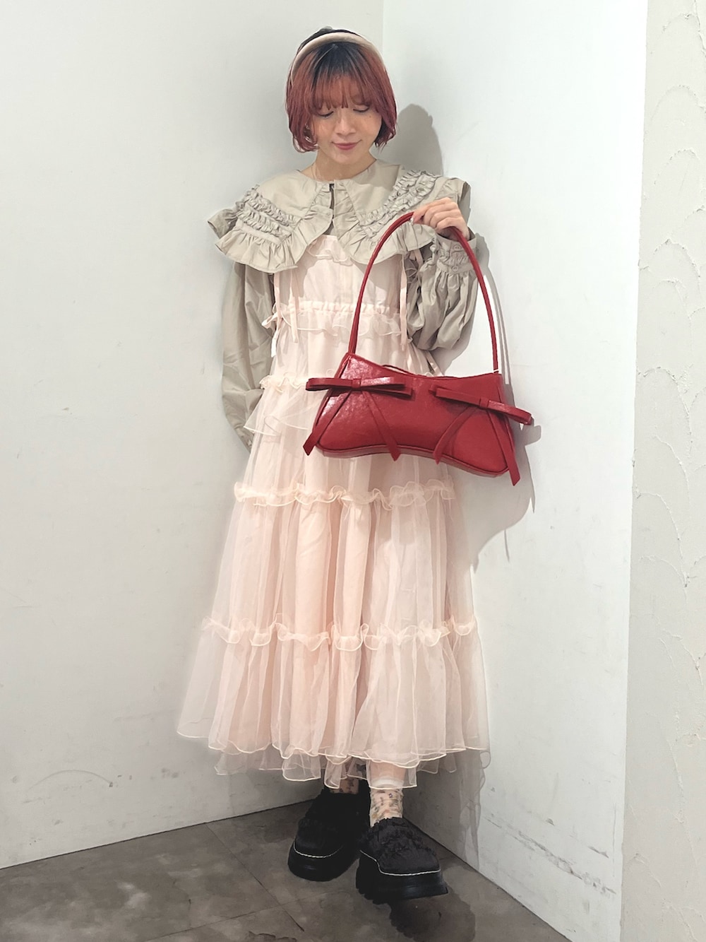 ベージュ系のシャツ/ブラウス、ピンク系のワンピース、レッド系のハンドバッグを着用したレディースの秋コーディネートの2枚目の写真