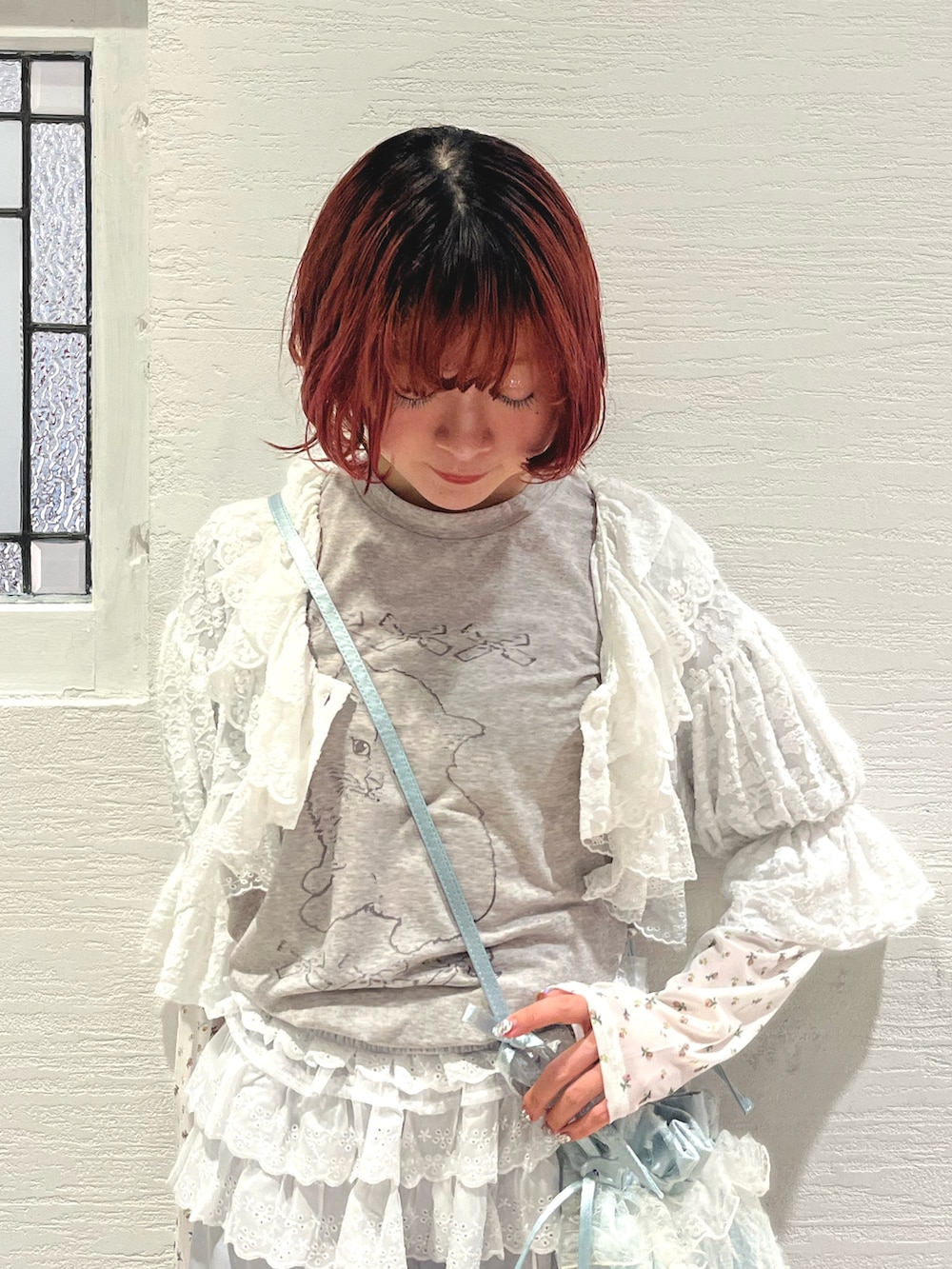 ブルー系のショルダーバッグ、グレー系のTシャツ/カットソー、ホワイト系のカーディガン/ボレロを着用したレディースの秋コーディネートの9枚目の写真