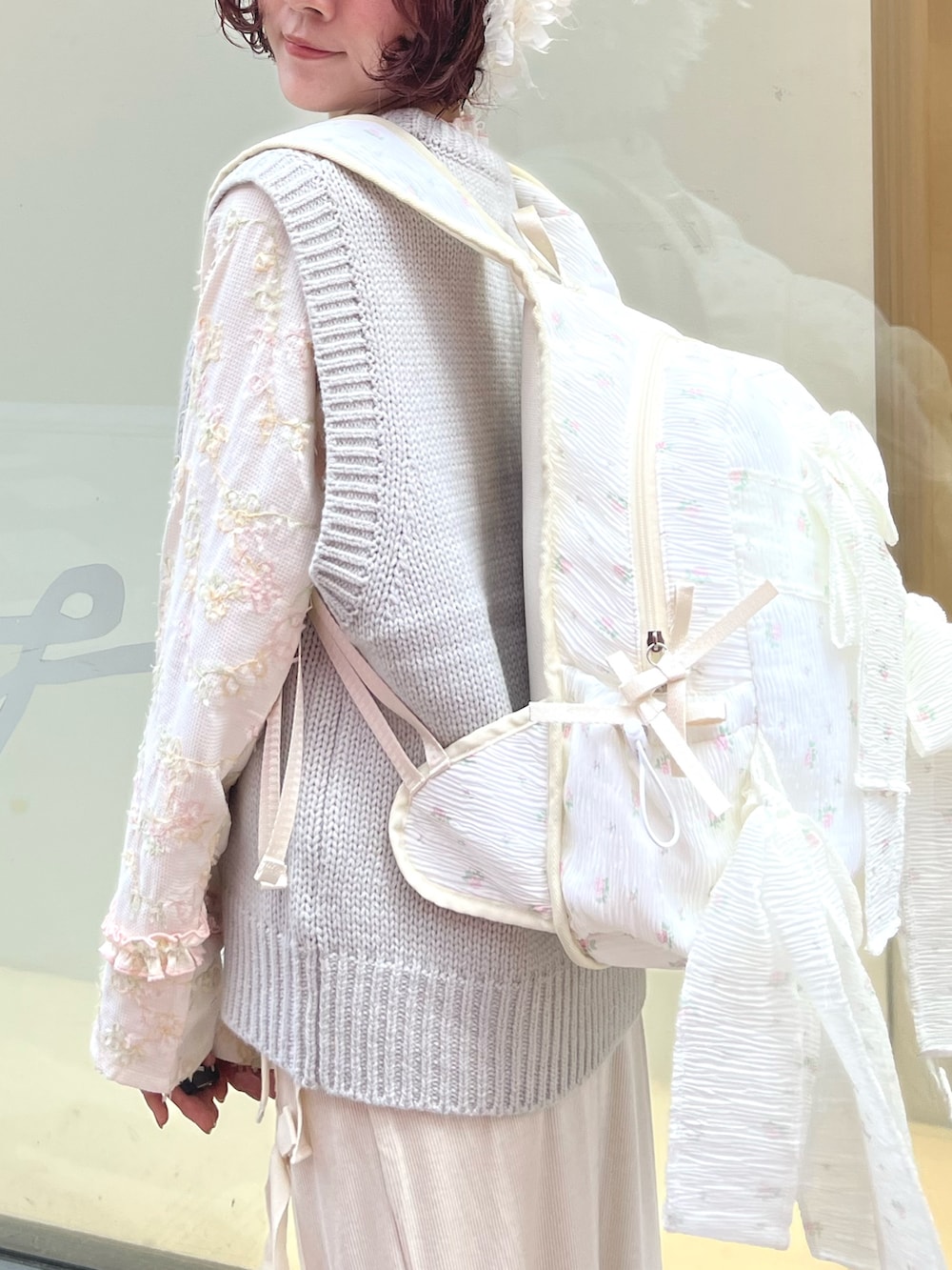 グレー系のベスト、ホワイト系のTシャツ/カットソー、ホワイト系のスカートを着用したレディースの秋コーディネートの7枚目の写真