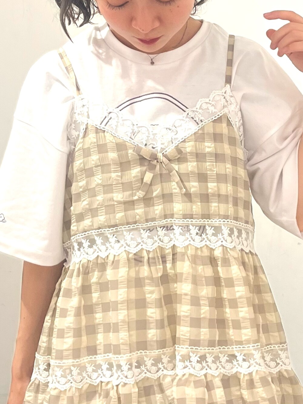 ベージュ系のキャミソール、ホワイト系のTシャツ/カットソー、ホワイト系のショルダーバッグを着用したレディースの春コーディネートの7枚目の写真