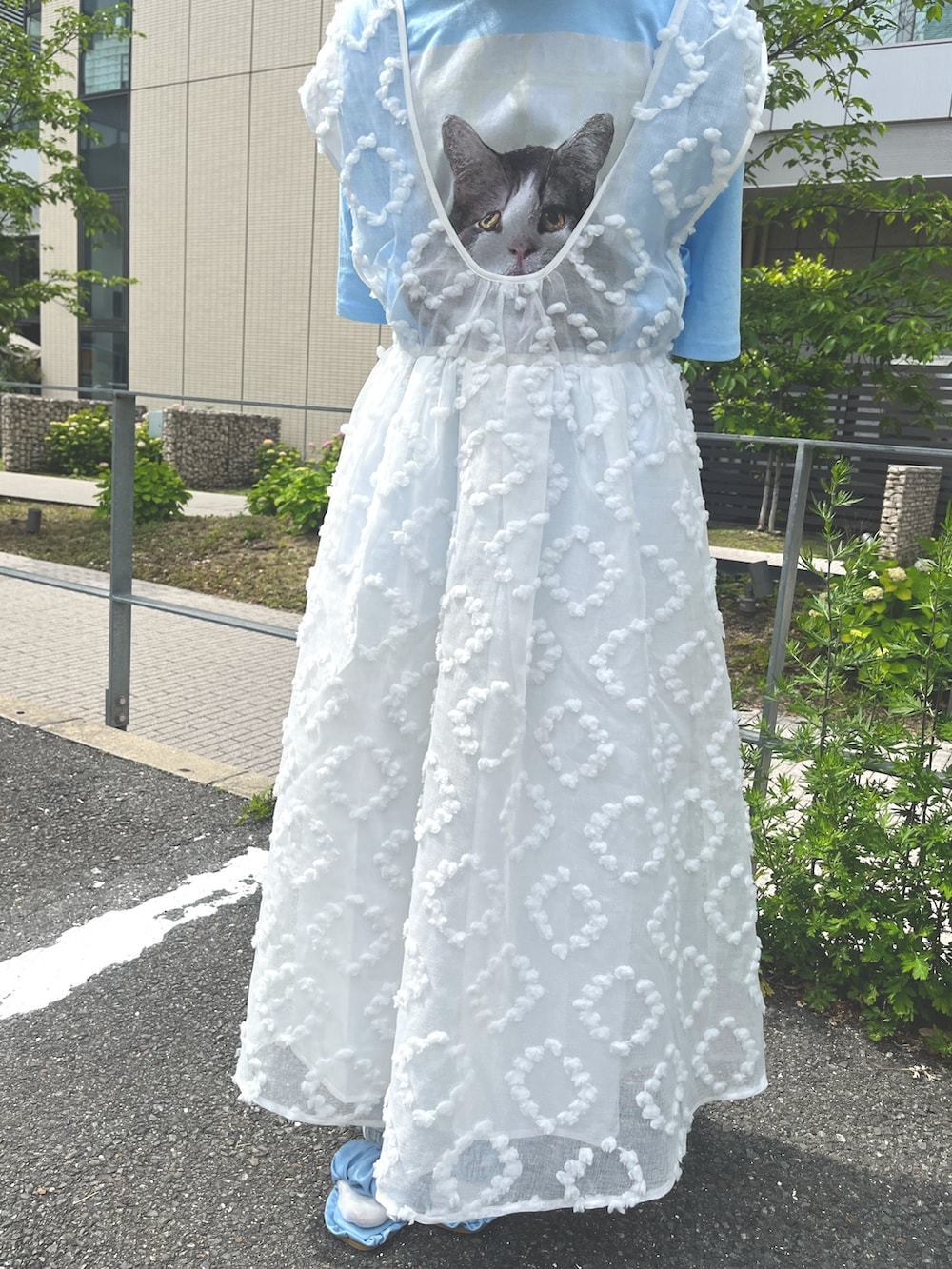 ホワイト系のジャンパースカート、ブルー系のTシャツ/カットソー、ブルー系のデニムパンツを着用したレディースの春コーディネートの9枚目の写真