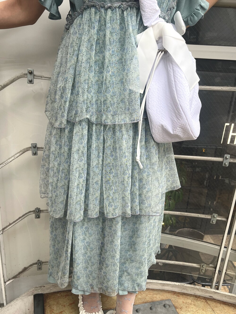 ホワイト系のショルダーバッグ、ブルー系のワンピース、グリーン系のワンピースを着用したレディースの夏コーディネートの9枚目の写真