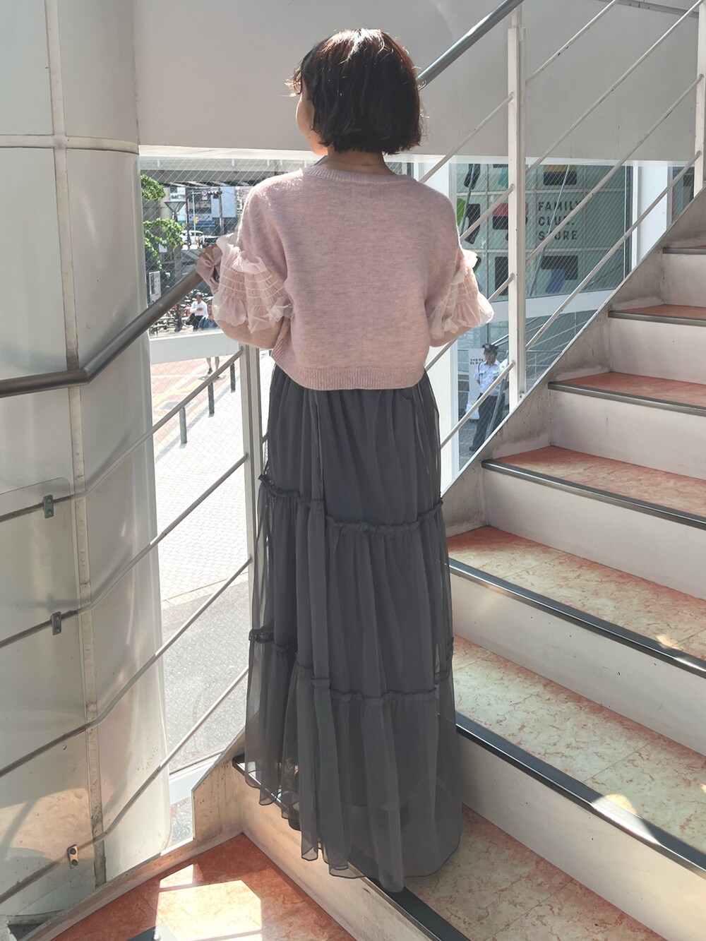 グレー系のワンピース、ピンク系のカーディガン/ボレロ、ホワイト系のTシャツ/カットソーを着用したレディースの秋コーディネートの4枚目の写真