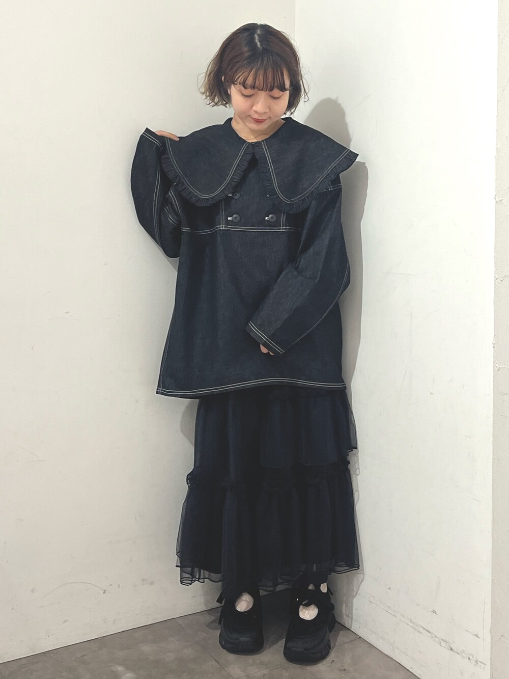 ホワイト系のトートバッグ、ブルー系のデニムジャケット、ブラック系のスカートを着用したレディースの秋コーディネートの3枚目の写真