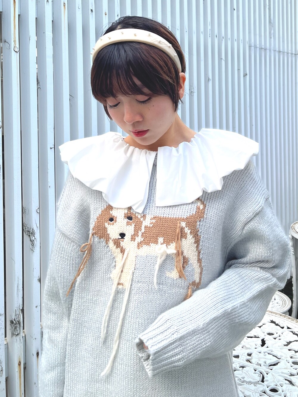 ブラック系のショルダーバッグ、ブルー系のニット/セーター、ホワイト系のシャツ/ブラウスを着用したレディースの冬コーディネートの8枚目の写真