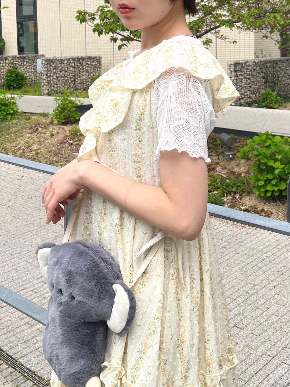 イエロー系のワンピース、ホワイト系のTシャツ/カットソー、グレー系のショルダーバッグを着用したレディースの春コーディネートの5枚目の写真