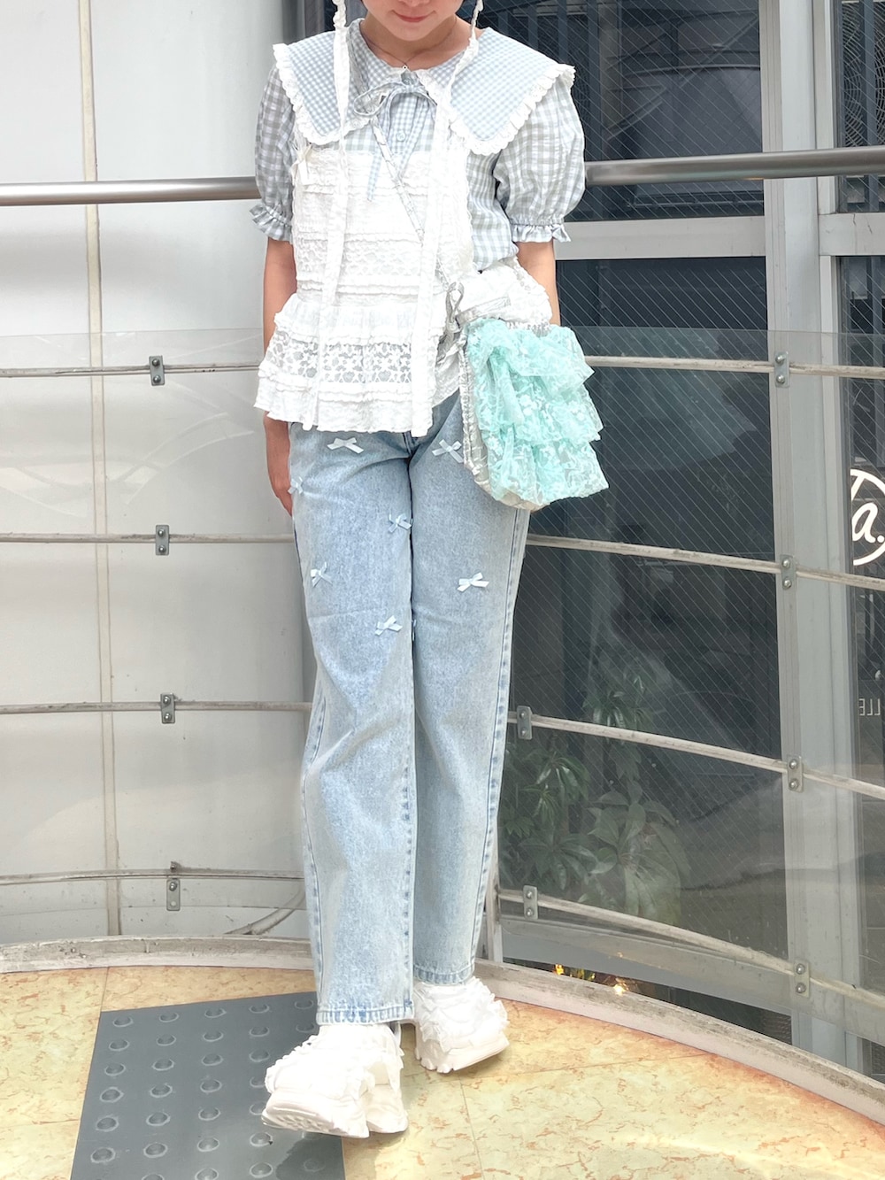 ホワイト系のキャミソール、グリーン系のシャツ/ブラウス、ブルー系のショルダーバッグを着用したレディースの春コーディネートの6枚目の写真