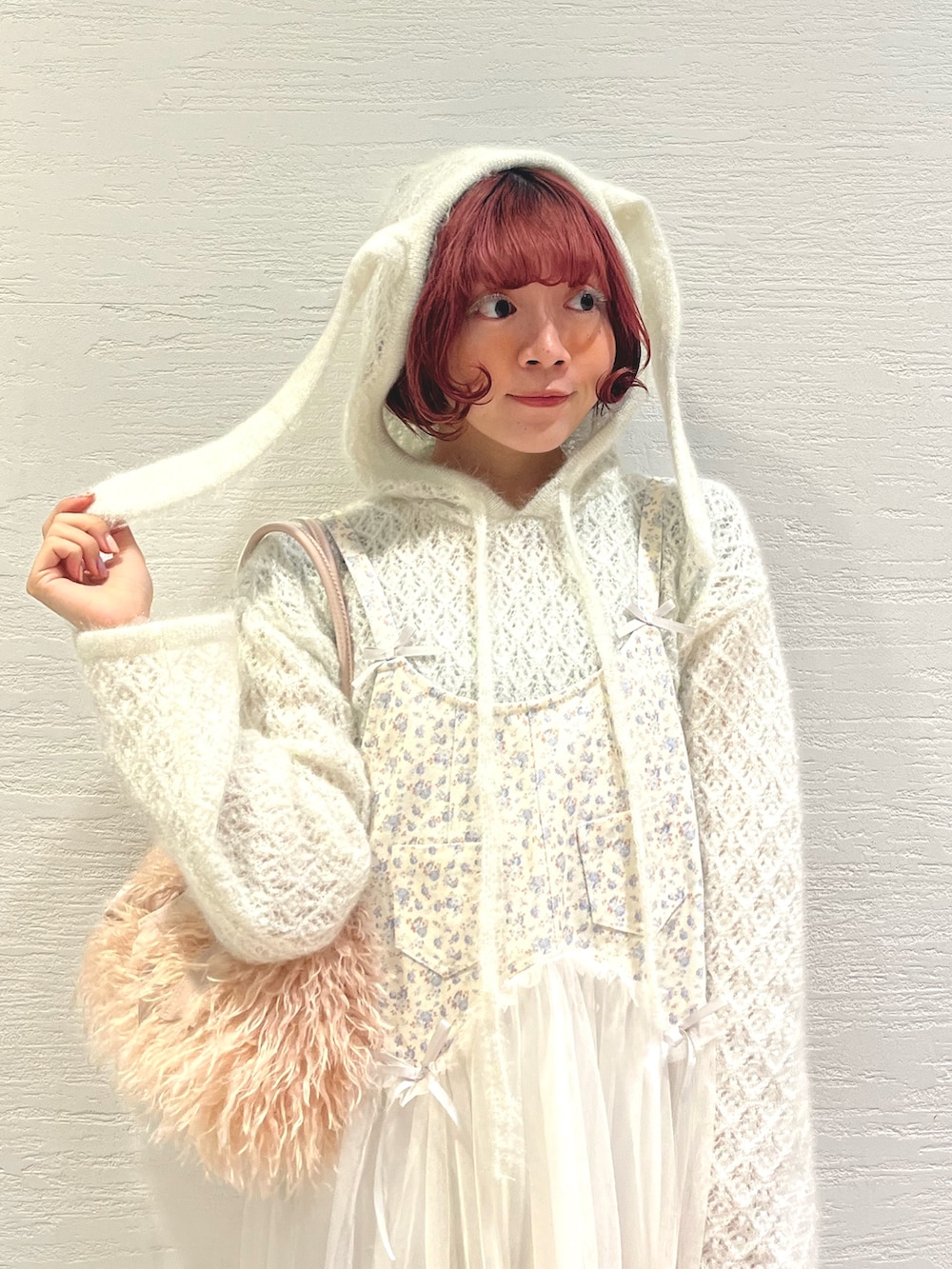 ピンク系のボストンバッグ、ホワイト系のニット/セーター、ホワイト系のワンピースを着用したレディースの秋コーディネートの6枚目の写真