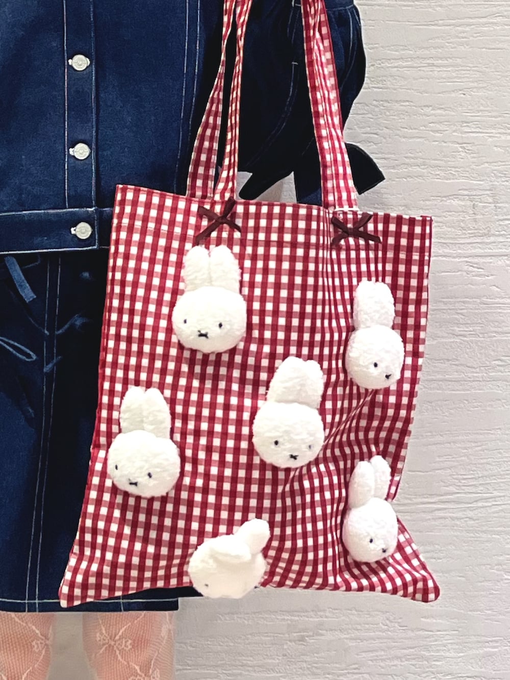 ブルー系のスカート、ブルー系のデニムジャケット、レッド系のトートバッグを着用したレディースの秋コーディネートの9枚目の写真