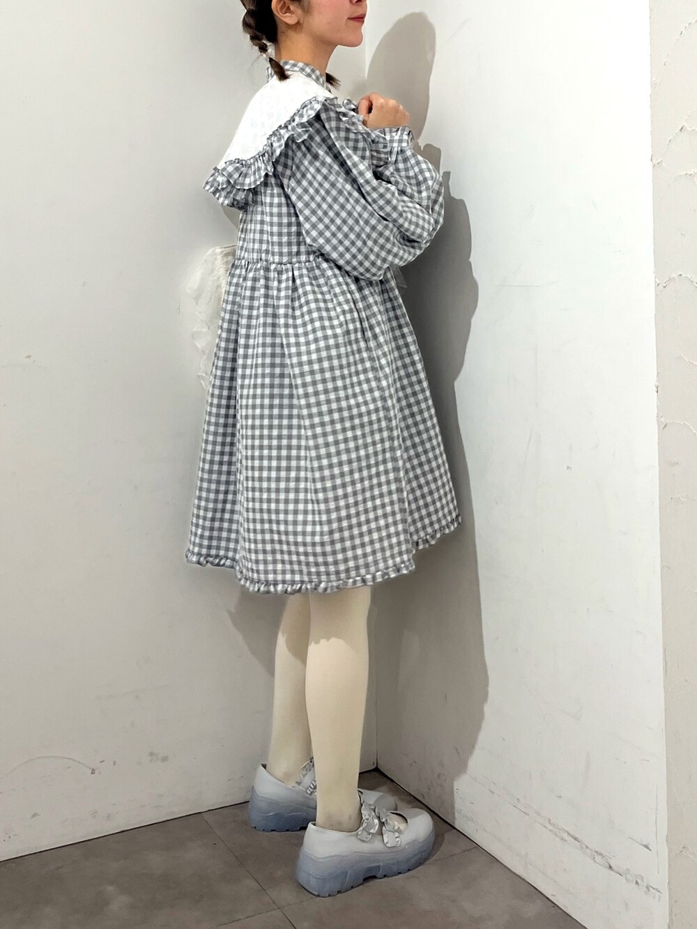 グレー系のワンピース、ホワイト系のトートバッグ、ブルー系のスニーカーを着用したレディースの春コーディネートの4枚目の写真