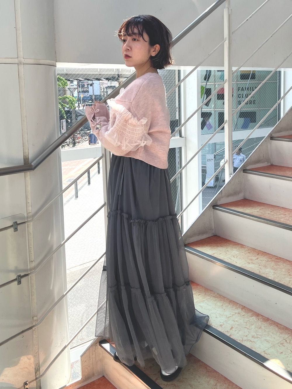 グレー系のワンピース、ピンク系のカーディガン/ボレロ、ホワイト系のTシャツ/カットソーを着用したレディースの秋コーディネートの3枚目の写真