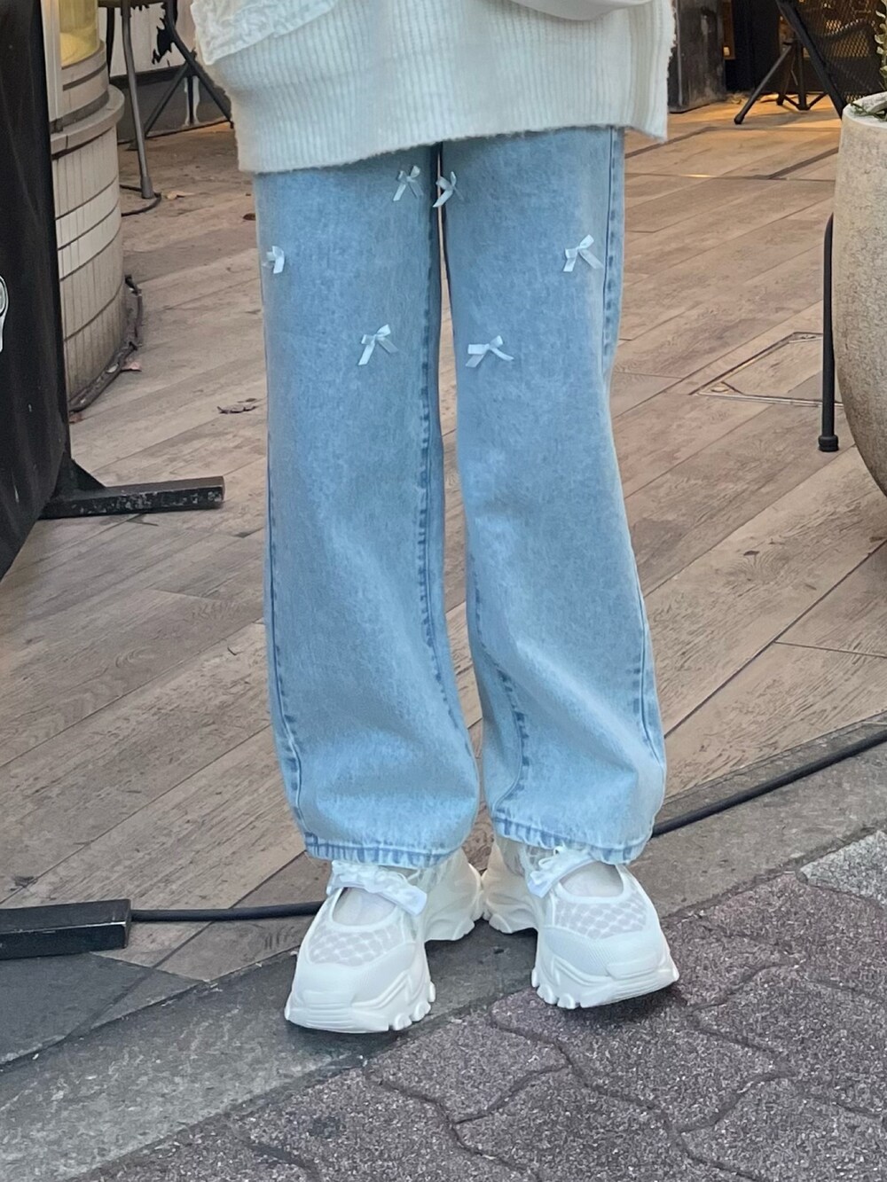 ホワイト系のショルダーバッグ、ホワイト系のニット/セーター、ブルー系のシャツ/ブラウスを着用したレディースの冬コーディネートの7枚目の写真