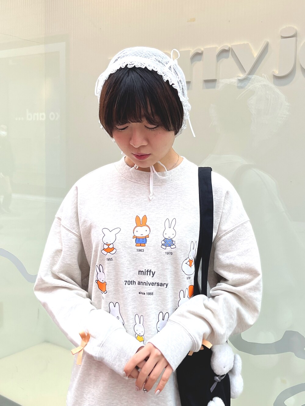 グレー系のスウェット、グレー系のスカート、ブラック系のスニーカーを着用したレディースの冬コーディネートの6枚目の写真