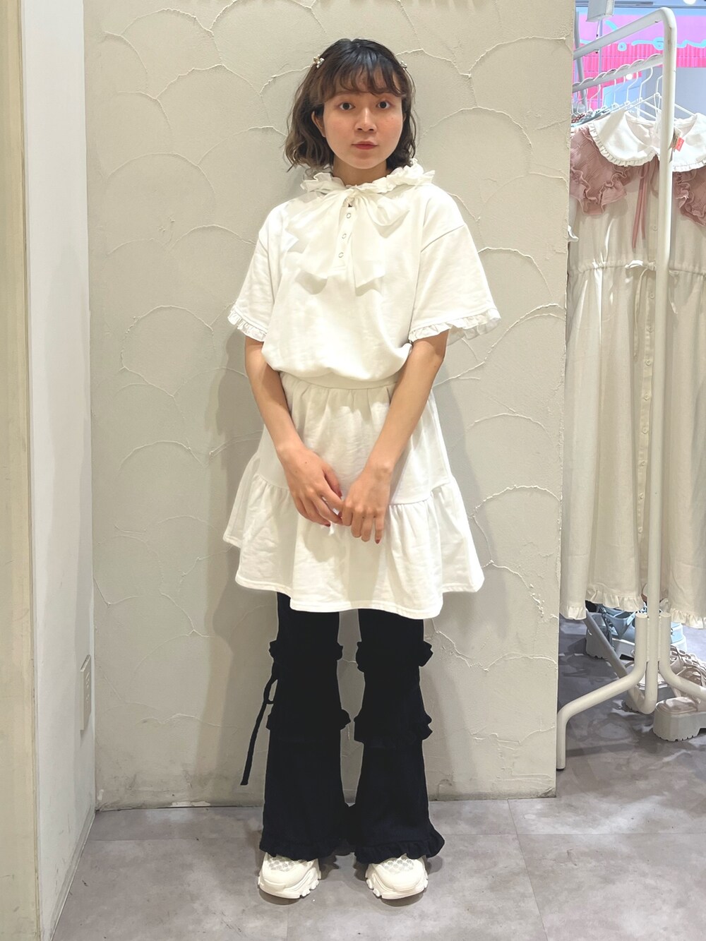 ホワイト系のワンピース、ブラック系のスウェットパンツ、ホワイト系のスニーカーを着用したレディースの夏コーディネートの2枚目の写真