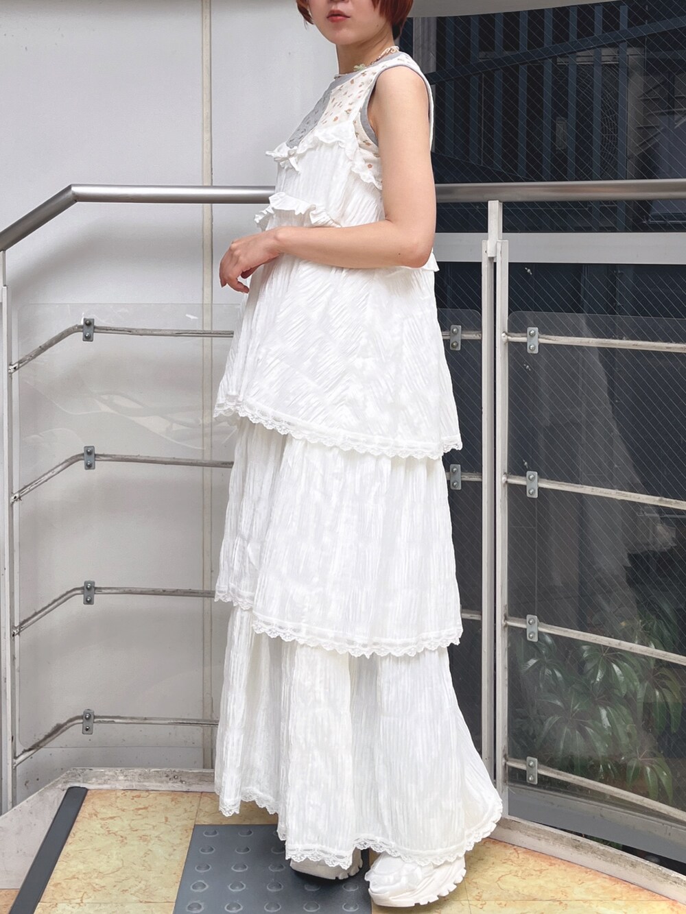 ホワイト系のワンピース、グレー系のタンクトップ、ホワイト系のスニーカーを着用したレディースの春コーディネートの2枚目の写真