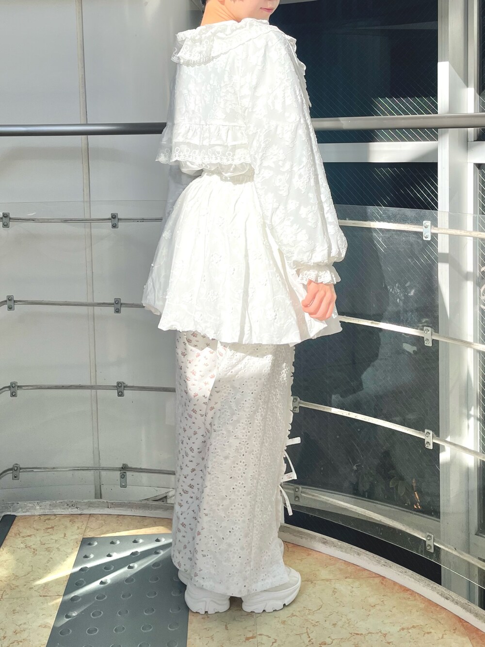 ホワイト系のスウェット、ホワイト系のカーディガン/ボレロ、ホワイト系のスカートを着用したレディースの冬コーディネートの3枚目の写真