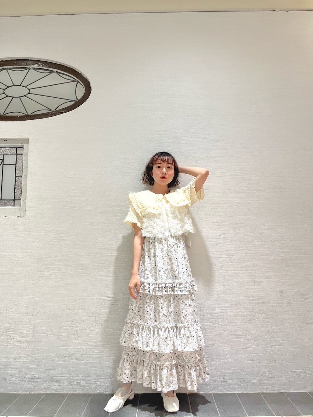 イエロー系のシャツ/ブラウス、ホワイト系のキャミソール、イエロー系のスカートを着用したレディースの夏コーディネートの3枚目の写真