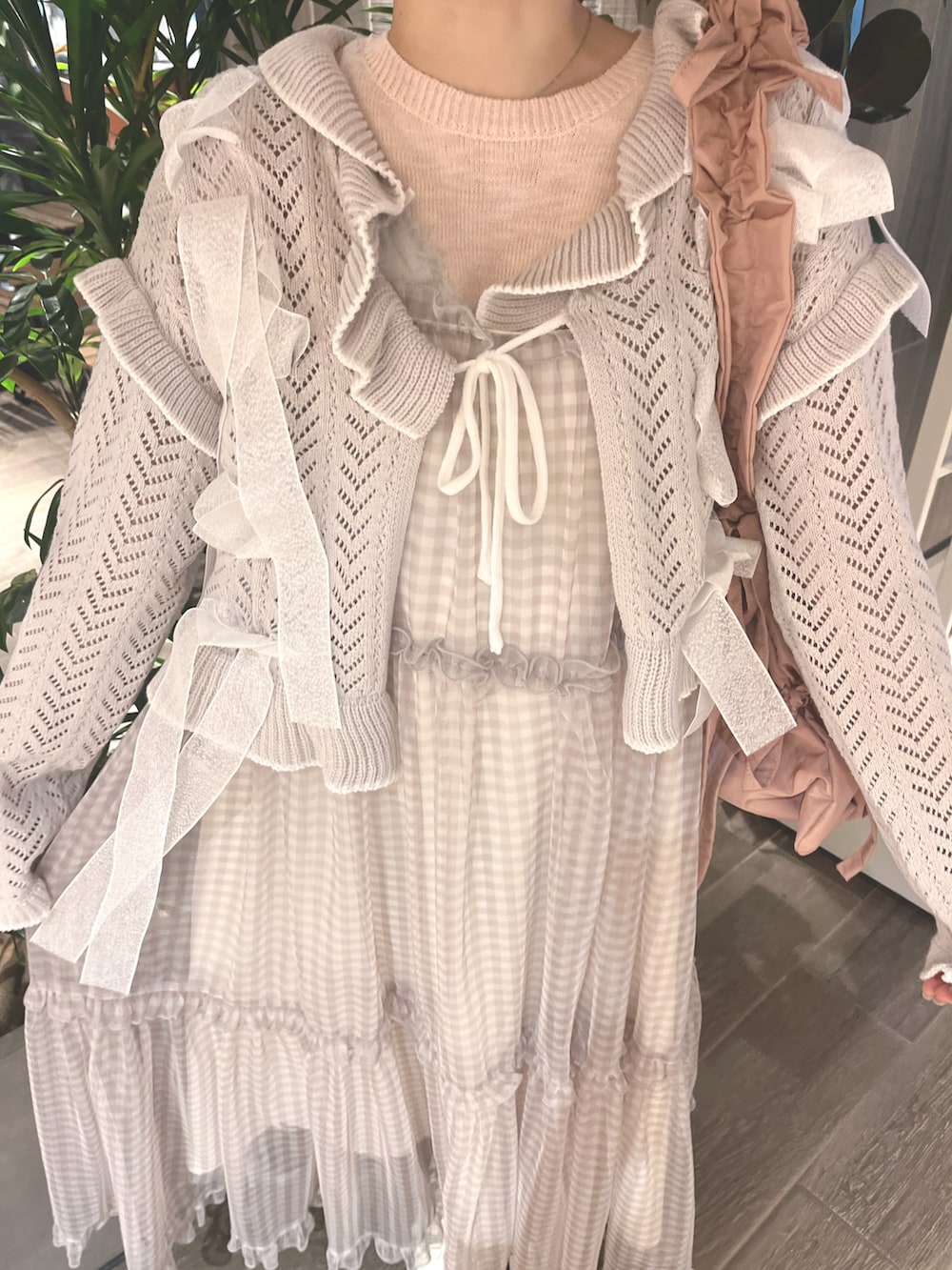 グレー系のカーディガン/ボレロ、ピンク系のニット/セーター、ベージュ系のワンピースを着用したレディースの春コーディネートの8枚目の写真