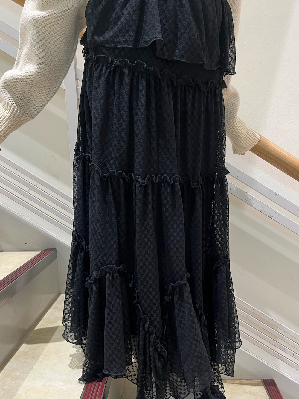 ブラック系のワンピース、ホワイト系のニット/セーター、ブラック系のパンプスを着用したレディースの冬コーディネートの9枚目の写真